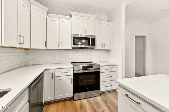 a kitchen with white cabinets and white appliances