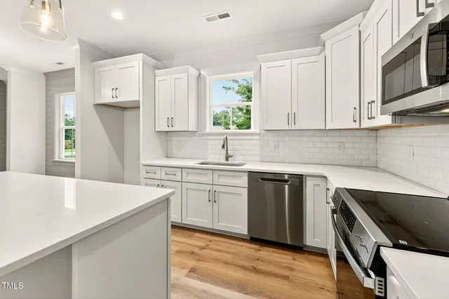a kitchen with granite countertop a sink stove and refrigerator