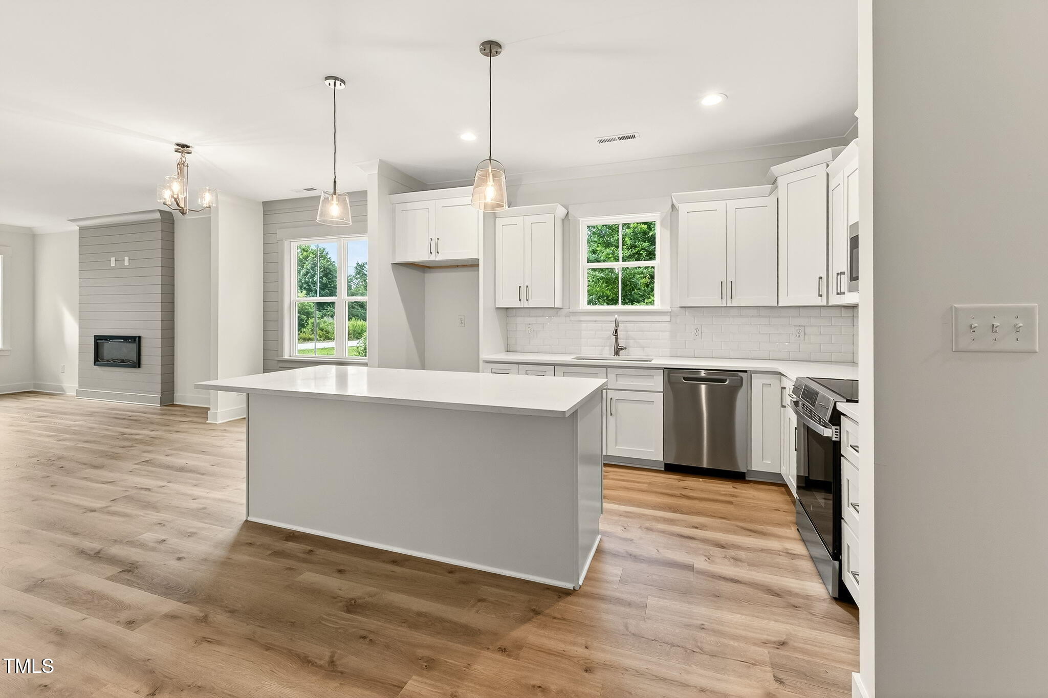 213 Maye Street Dunn, NC 28334 - Photo 20 of 45 a kitchen with stainless steel appliances granite countertop a sink a window and wooden floors