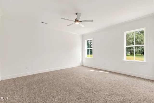an empty room with a window and a ceiling fan