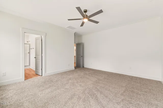 an empty room with ceiling fan and window