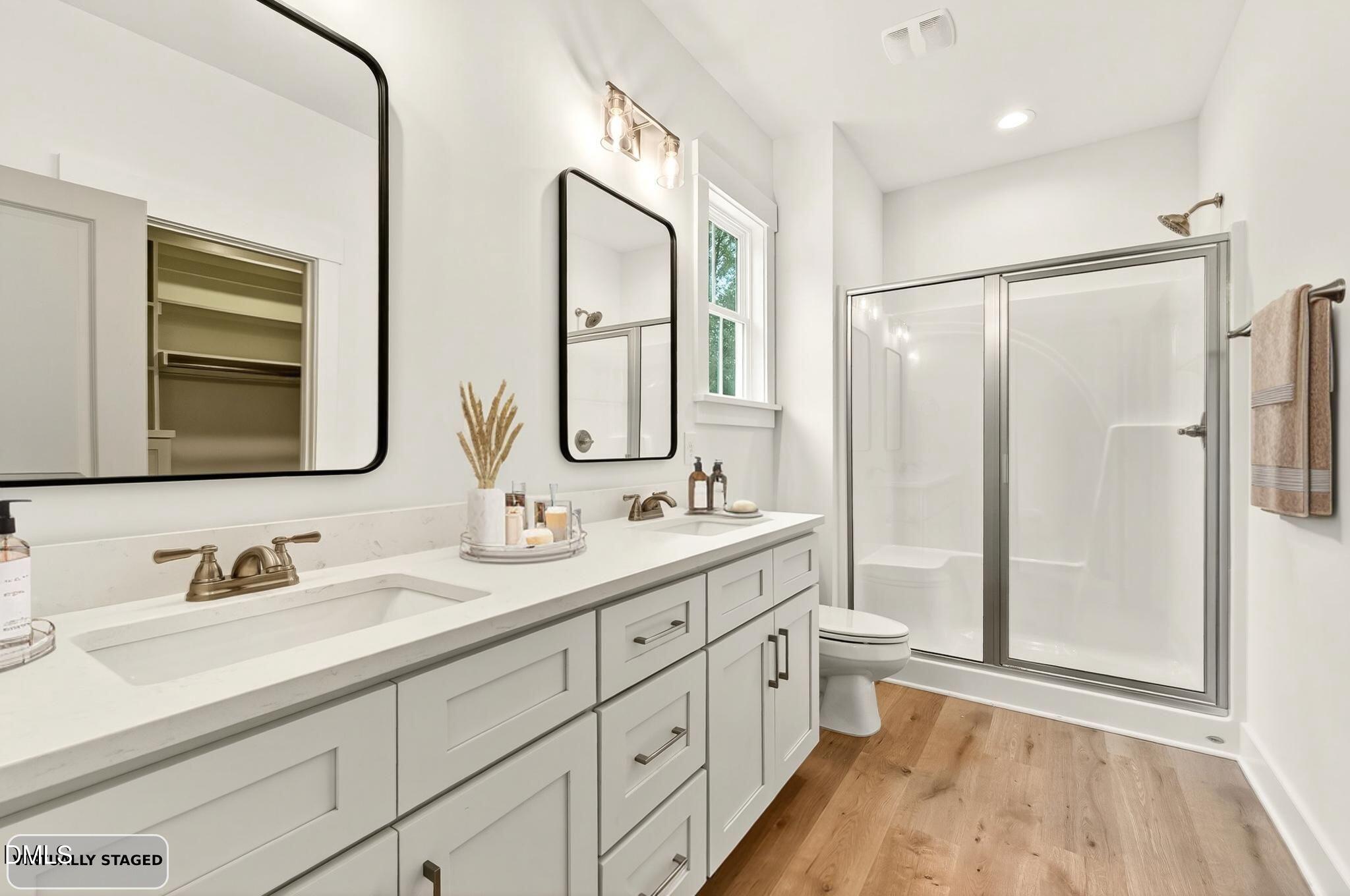 213 Maye Street Dunn, NC 28334 - Photo 24 of 45 a bathroom with double vanity sink a mirror and a shower