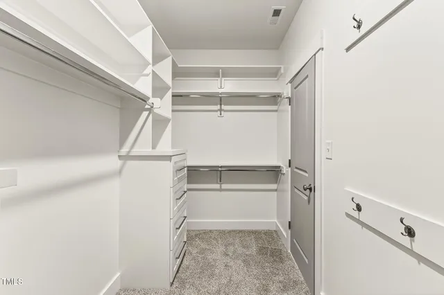 a view of walk in closet with empty racks