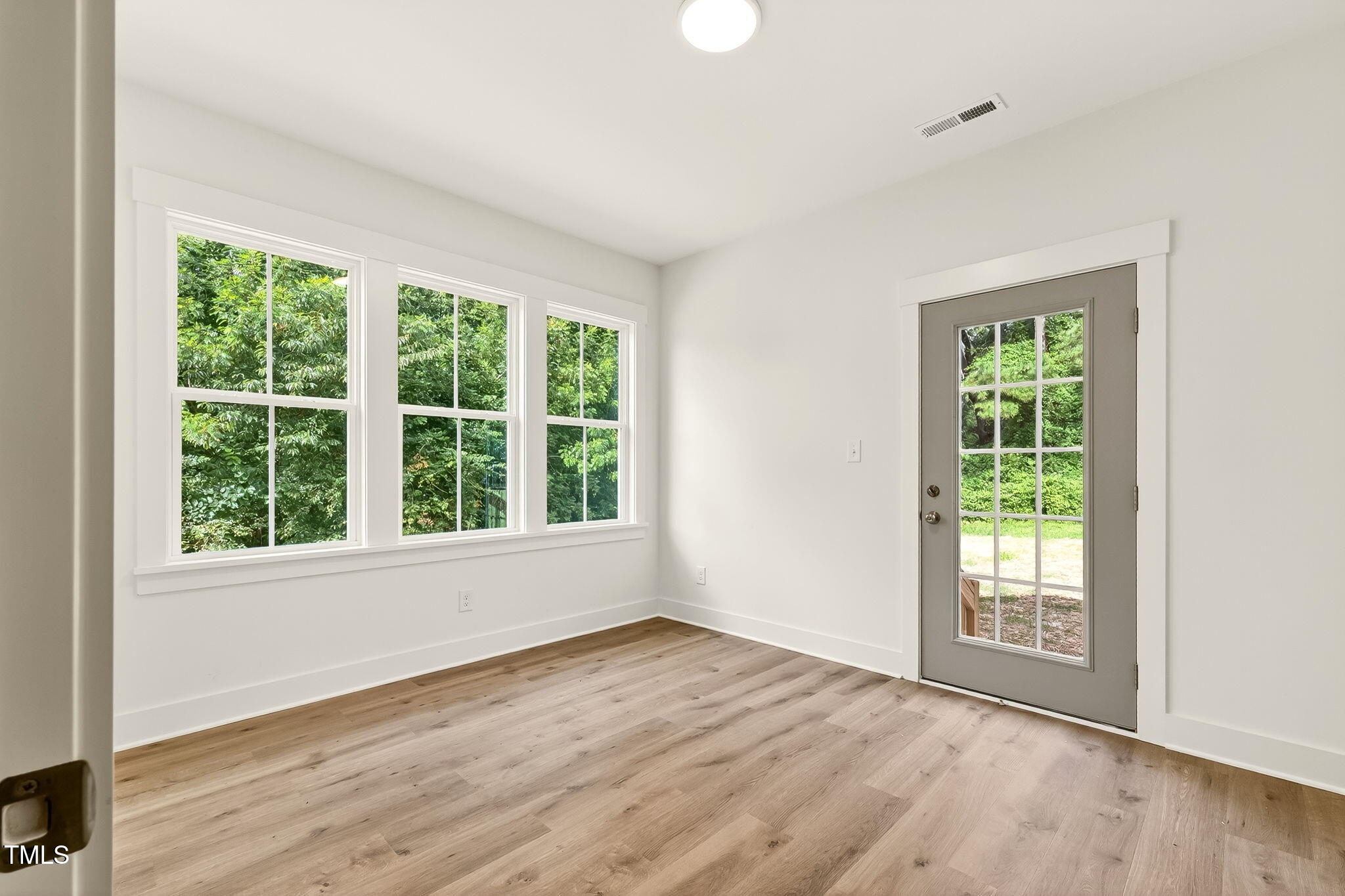 213 Maye Street Dunn, NC 28334 - Photo 38 of 45 a view of an empty room with wooden floor and a window