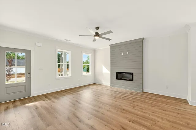 an empty room with windows and fireplace