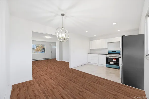 a view of a kitchen with a sink and dishwasher a refrigerator with wooden floor