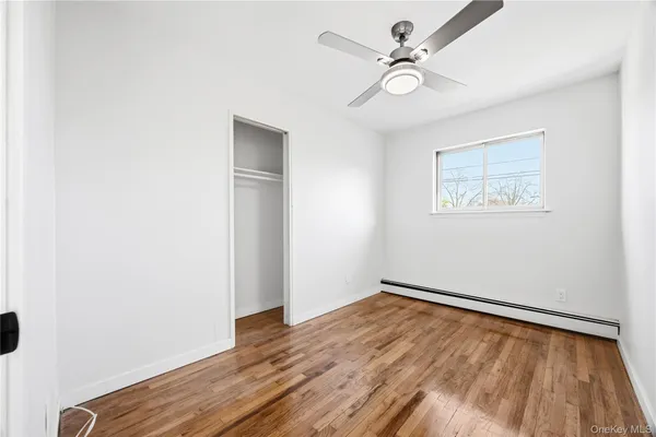 an empty room with a window and a ceiling fan