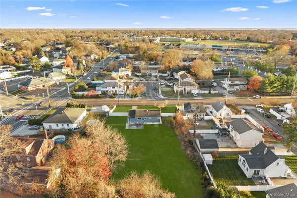 an aerial view of a city with lots of residential buildings ocean and mountain view in back