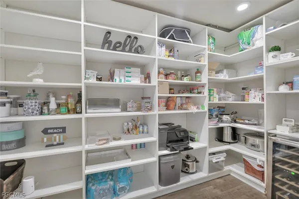 a kitchen with a lot of white cabinets and a wooden floor