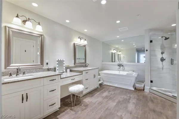 a large bathroom with a double vanity sink a mirror and a bathtub