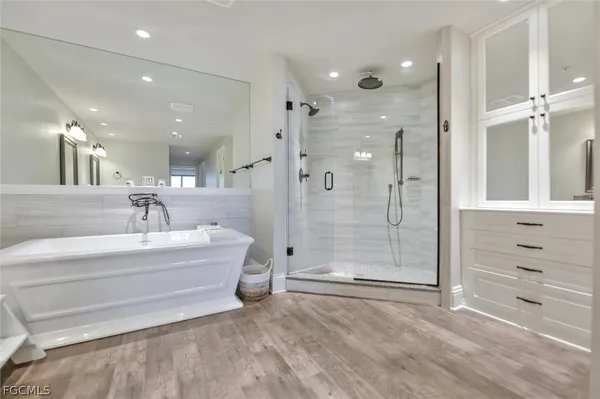 a bathroom with a bathtub shower sink and mirror