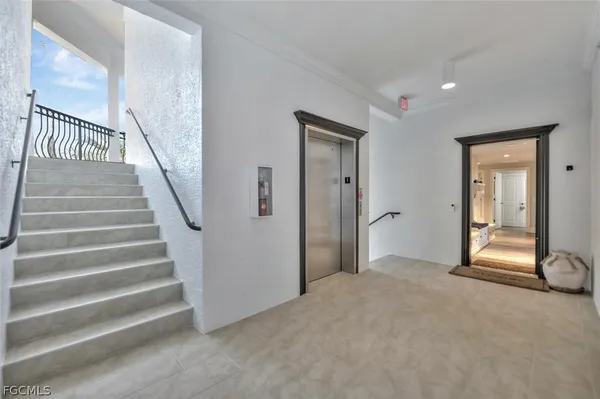 a view of an empty room with stairs and a fireplace