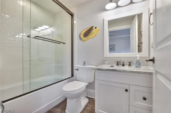 a bathroom with a granite countertop sink toilet and shower
