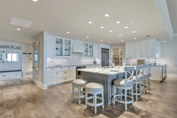 a kitchen with a dining table chairs wooden cabinets and stainless steel appliances