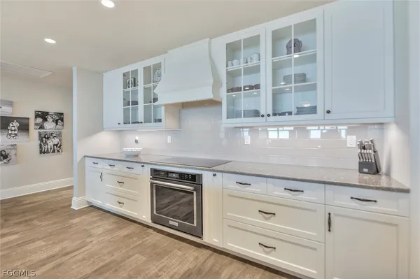 a kitchen with granite countertop white cabinets and white stainless steel appliances