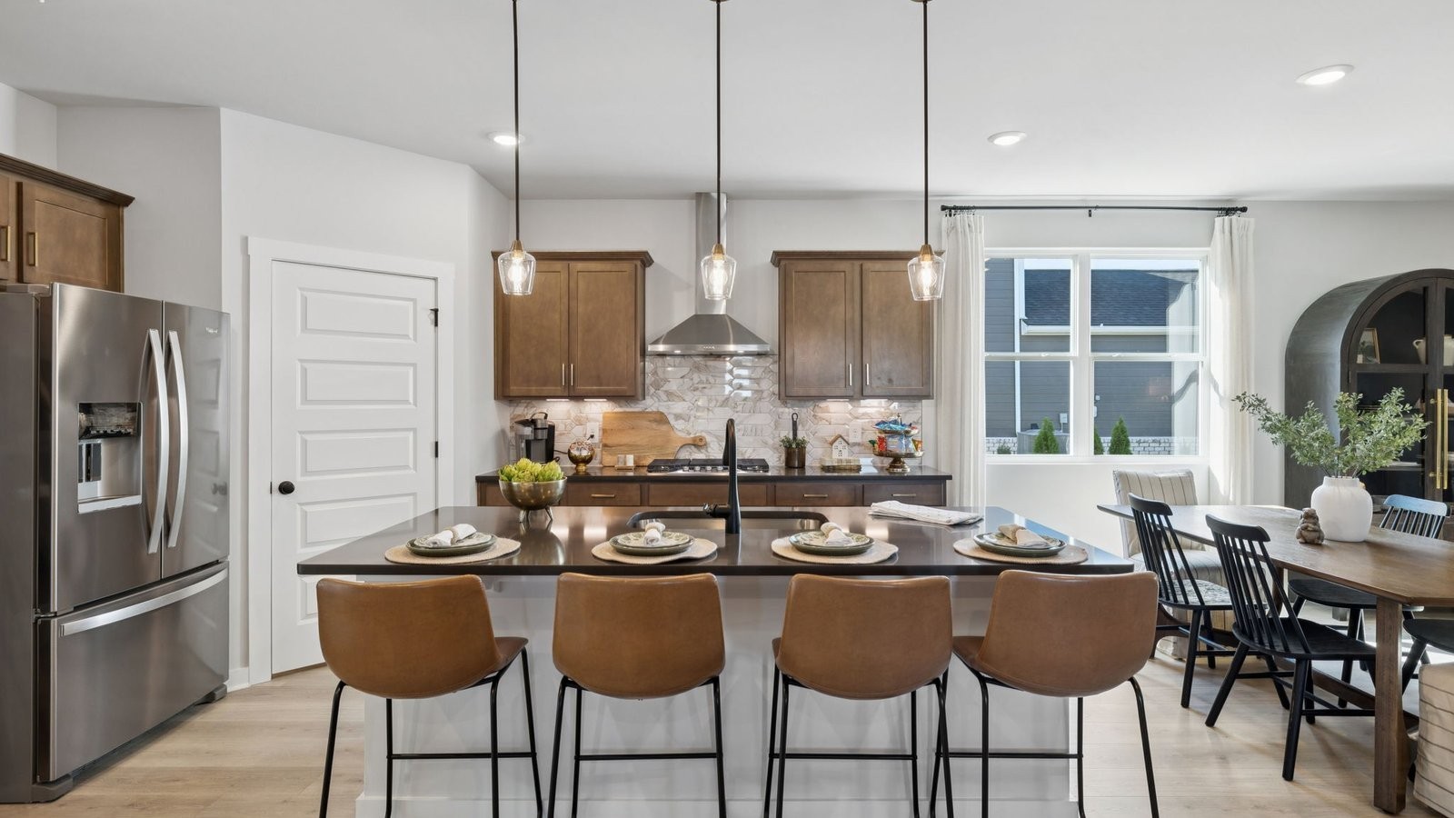 305 Harvest Point Boulevard Spring Hill, TN 37174 - Photo 17 of 48 a kitchen with stainless steel appliances granite countertop a stove a refrigerator a sink dishwasher a dining table and chairs with wooden floor