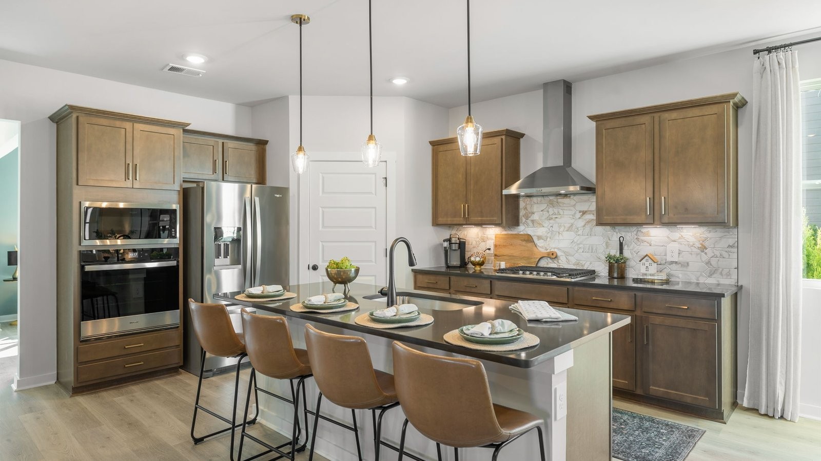 305 Harvest Point Boulevard Spring Hill, TN 37174 - Photo 23 of 48 a kitchen with stainless steel appliances a dining table chairs stove and refrigerator