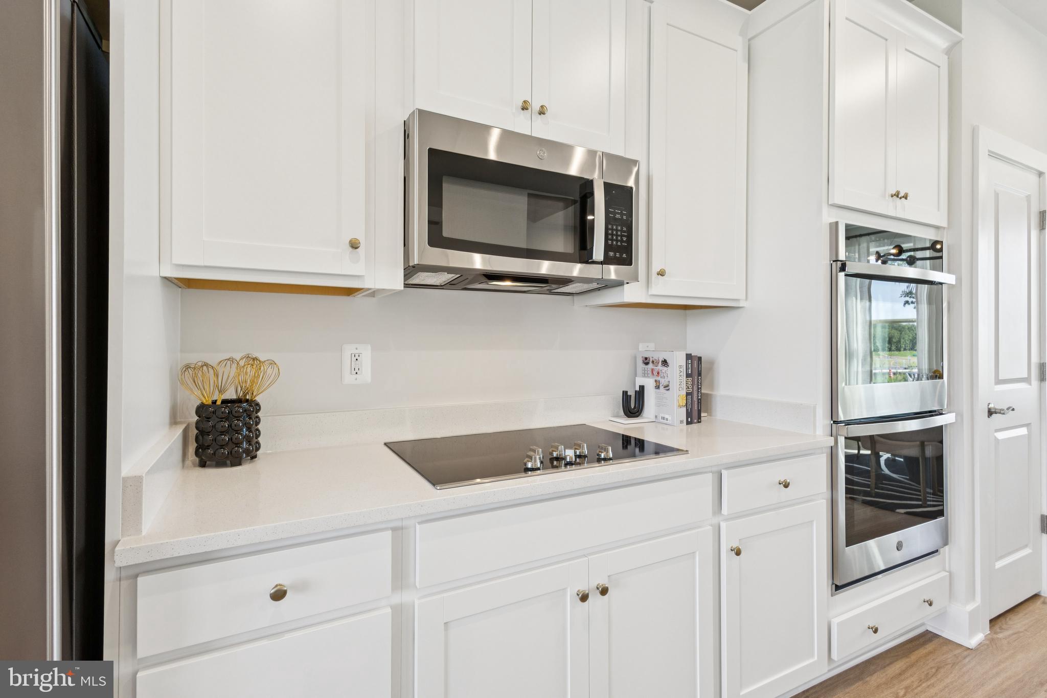11217 Einstein Street Manassas, VA 20110 - Photo 7 of 26 a kitchen with stainless steel appliances granite countertop white cabinets and a stove