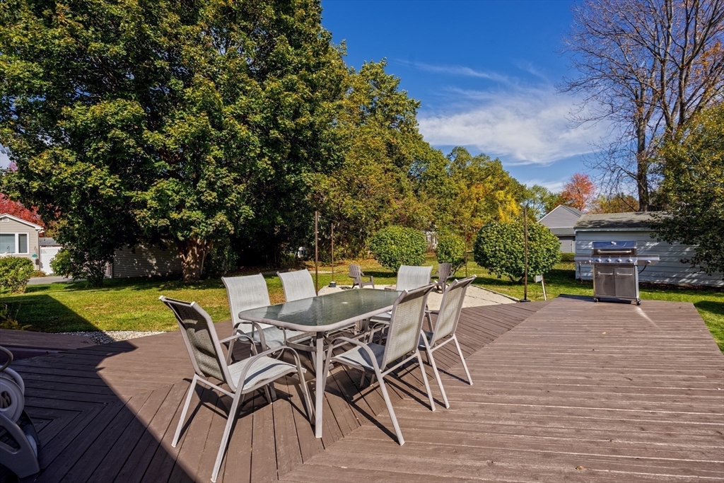 148 Yale Street Ludlow, MA 01056 - Photo 33 of 39 a view of a patio with table and chairs under an umbrella with wooden floor and fence