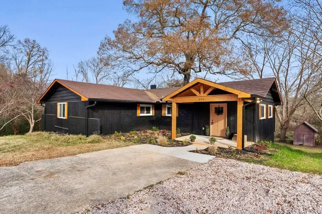 a front view of a house with a yard covered in snow