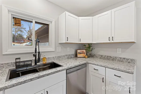 a kitchen with granite countertop white cabinets and white appliances