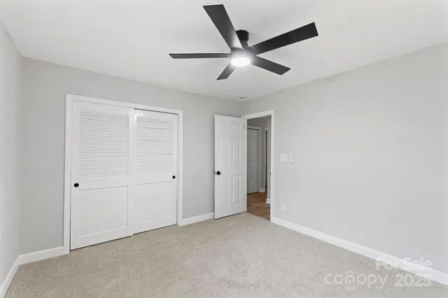 an empty room with a window and a ceiling fan