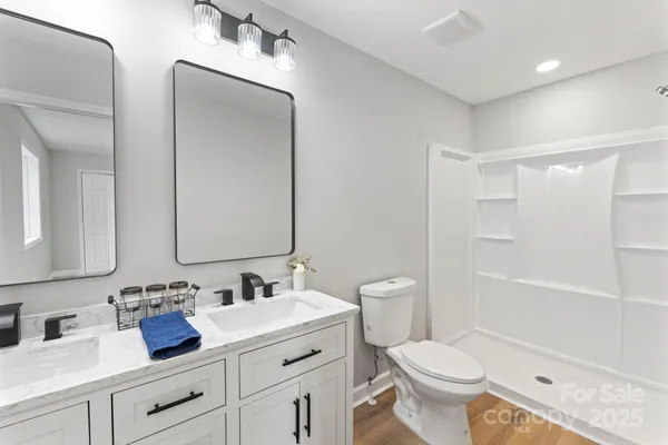 a bathroom with double vanity sinks and a mirror