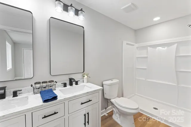 a bathroom with double vanity sinks and a mirror