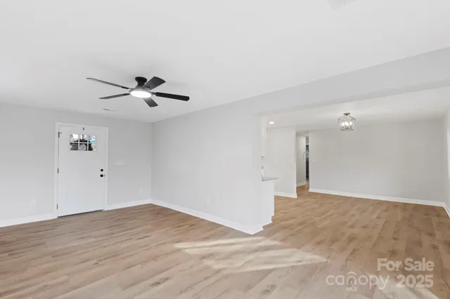 a view of a livingroom with a ceiling fan & a window