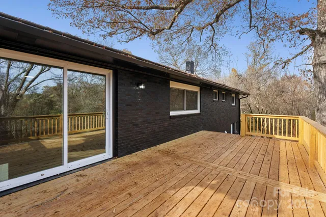 a balcony with wooden floor and trees