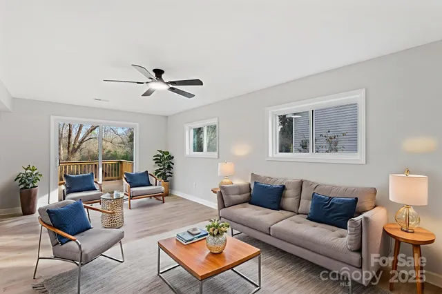 a living room with furniture a table and a large window