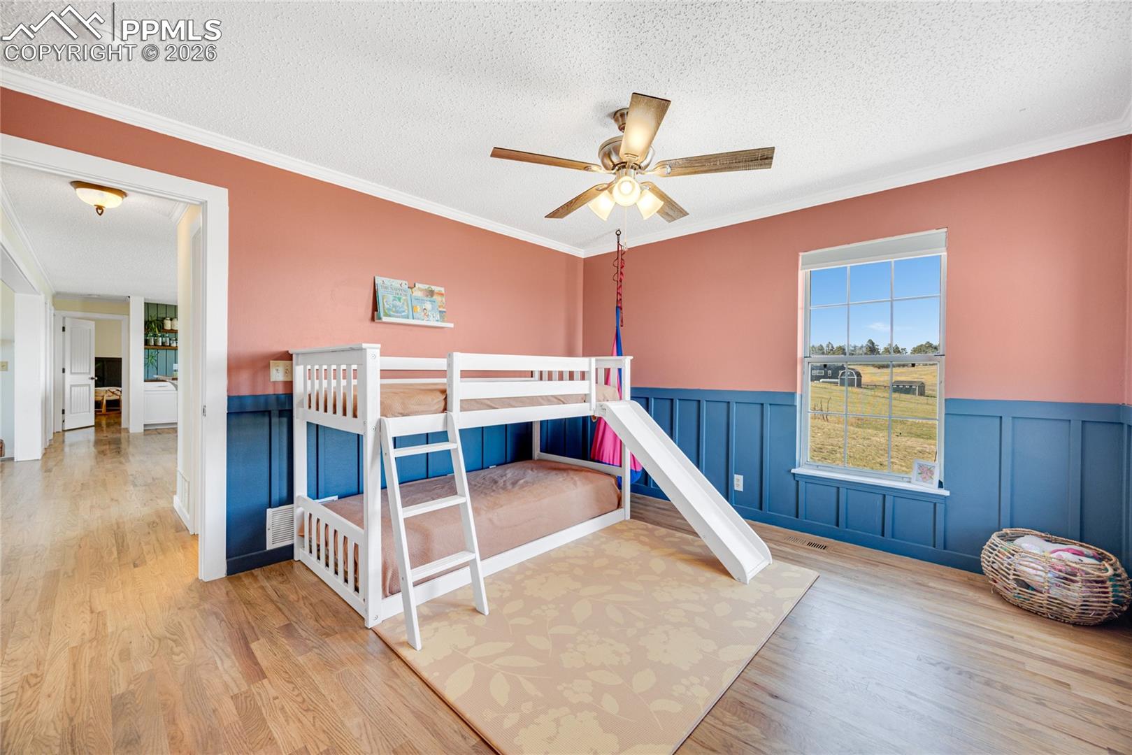 17520 Fremont Fort Road Peyton, CO 80831 - Photo 17 of 42 This interior space features hardwood flooring, custom wainscoting, a ceiling fan, and a window providing a view of the outdoors