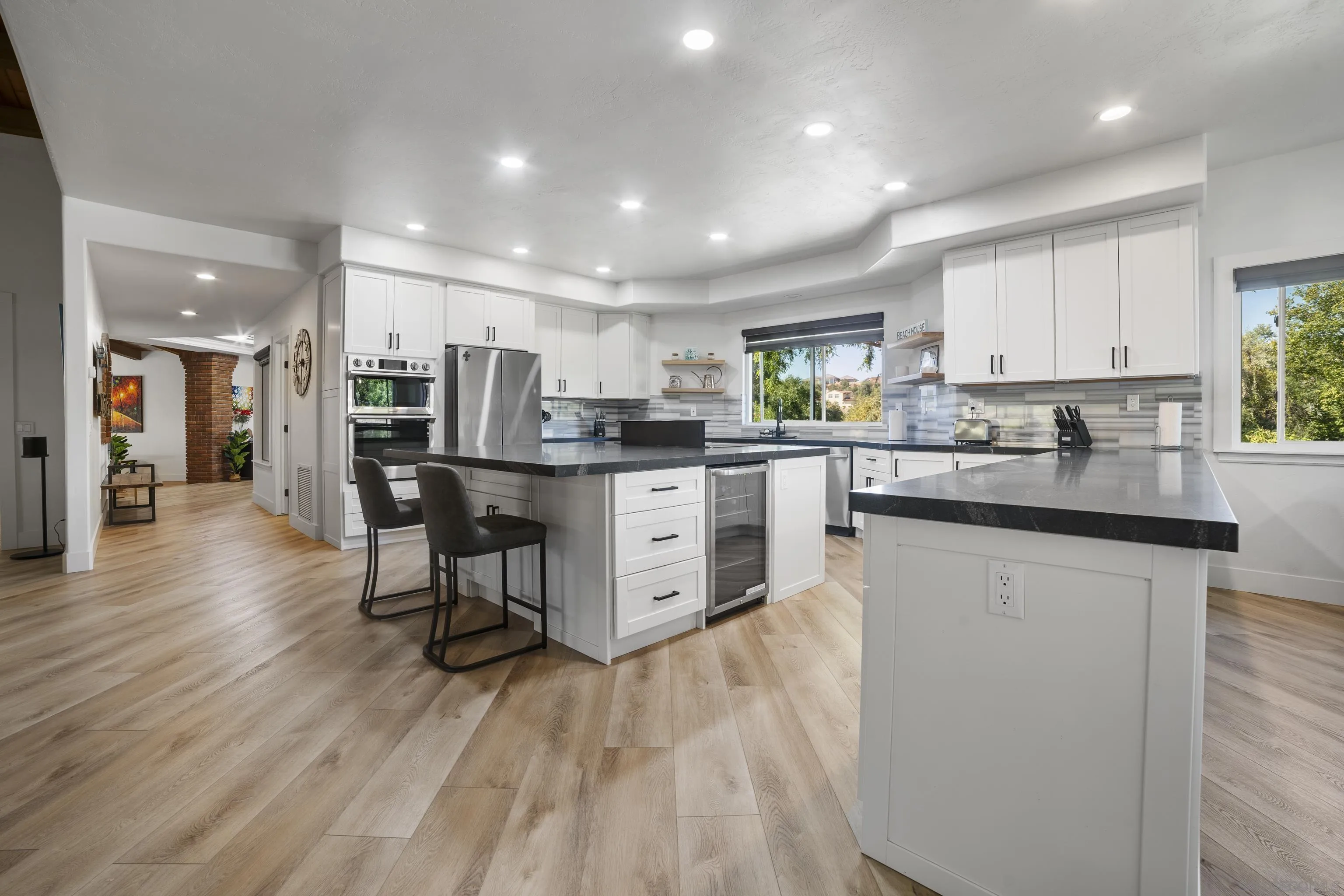 4062 La Canada Road Fallbrook, CA 92028 - Photo 17 of 63 a kitchen with stainless steel appliances kitchen island granite countertop wooden floors and white cabinets