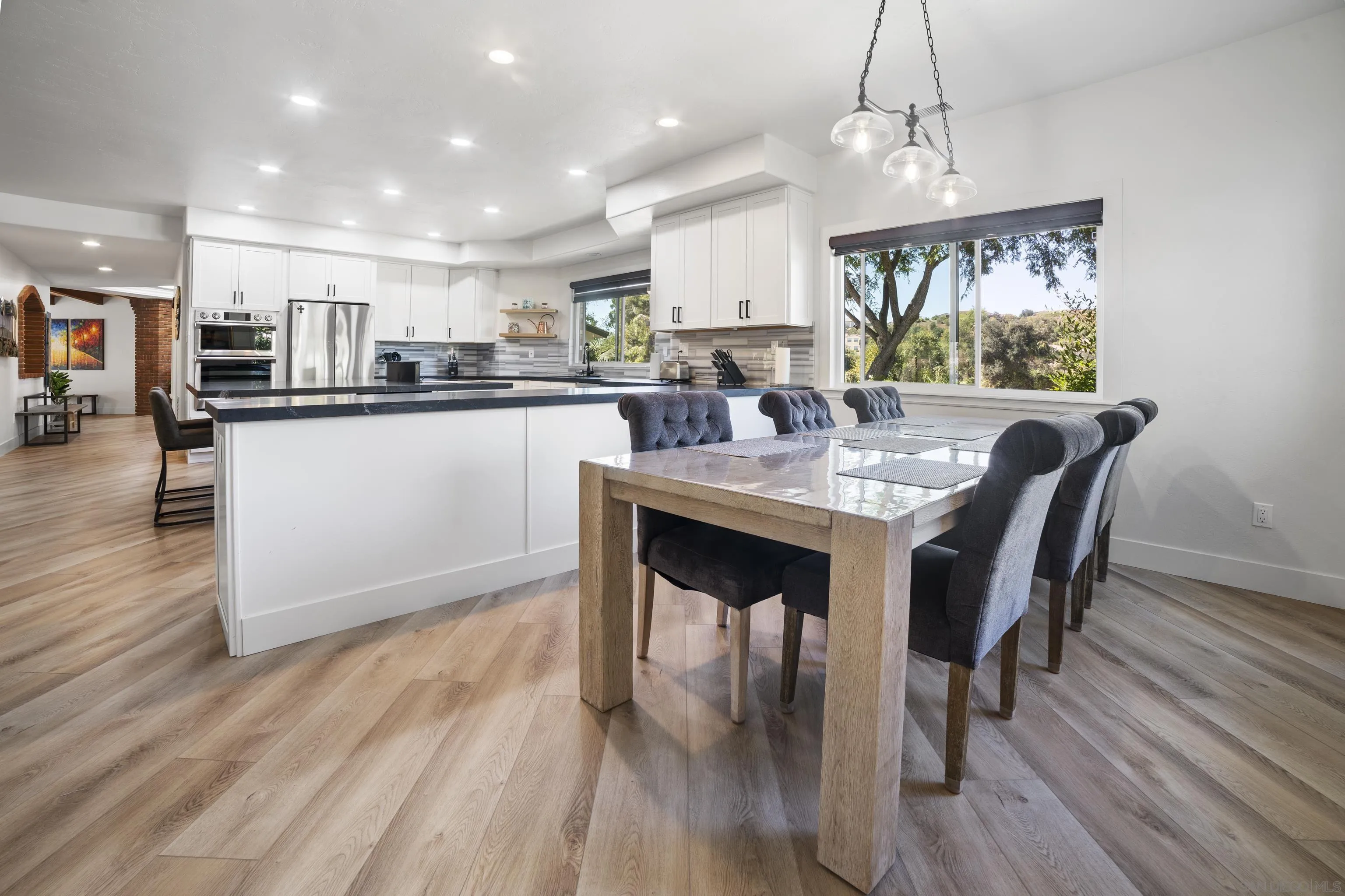 4062 La Canada Road Fallbrook, CA 92028 - Photo 20 of 63 a kitchen with a dining table chairs refrigerator and cabinets