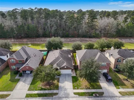 an aerial view of residential houses with outdoor space and lake view