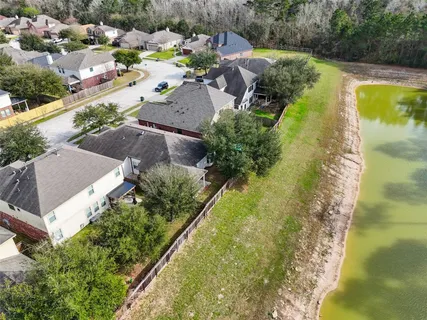 an aerial view of residential houses with outdoor space and trees