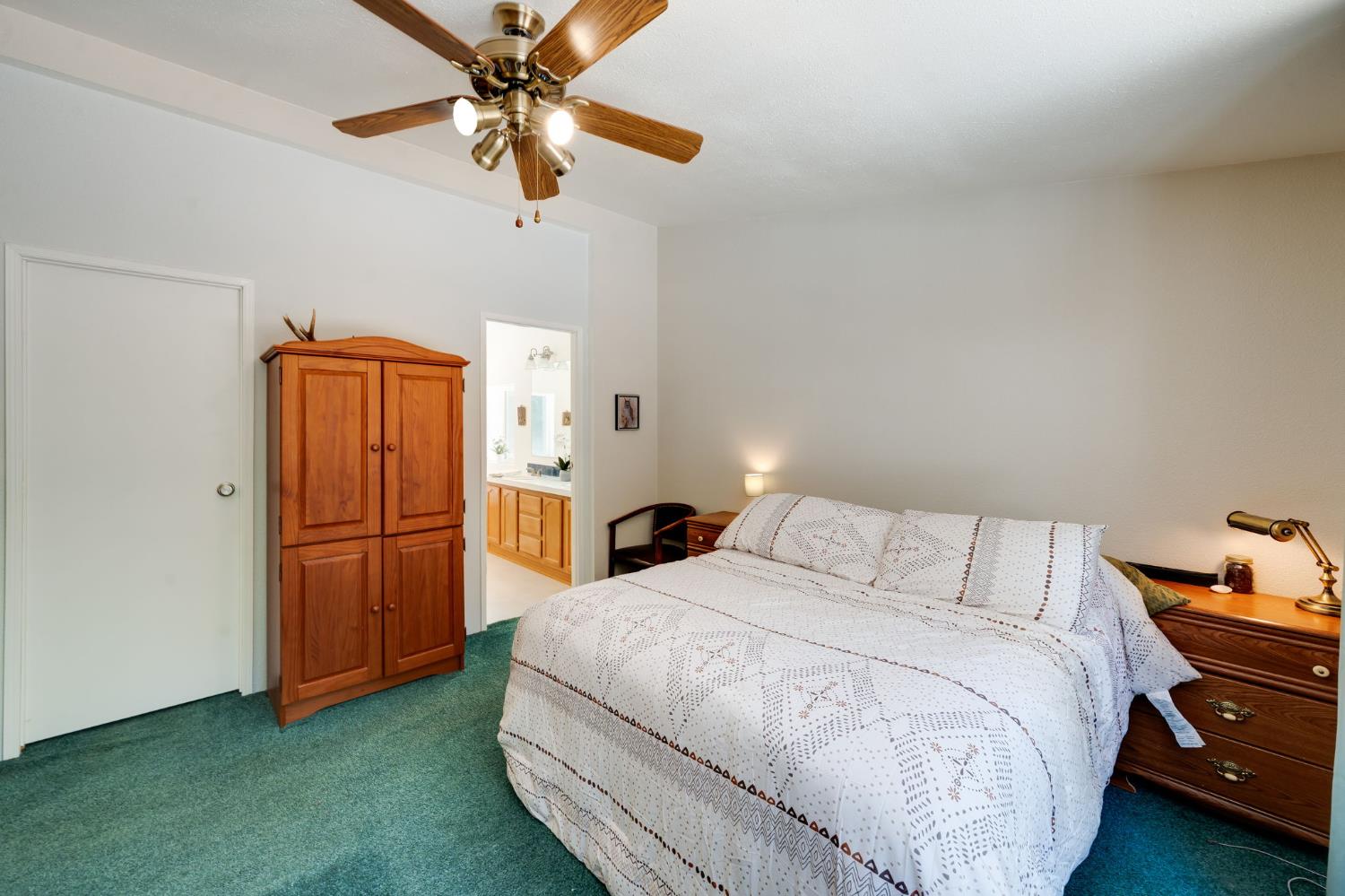 28722 Wood Road Pioneer, CA 95666 - Photo 16 of 39 a bedroom with a bed and a chandelier
