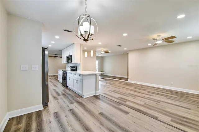 a view of large kitchen with kitchen island stainless steel appliances refrigerator stove and oven
