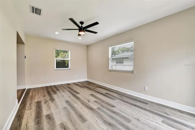 a view of empty room with wooden floor and window