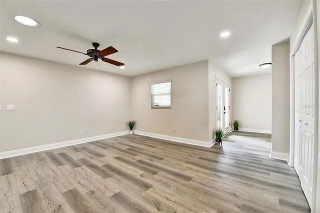 a view of empty room with wooden floor and fan
