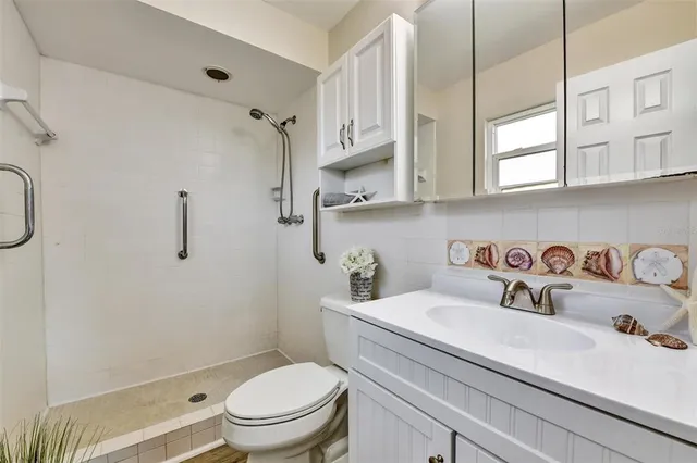 a bathroom with a granite countertop sink a toilet and a shower curtain