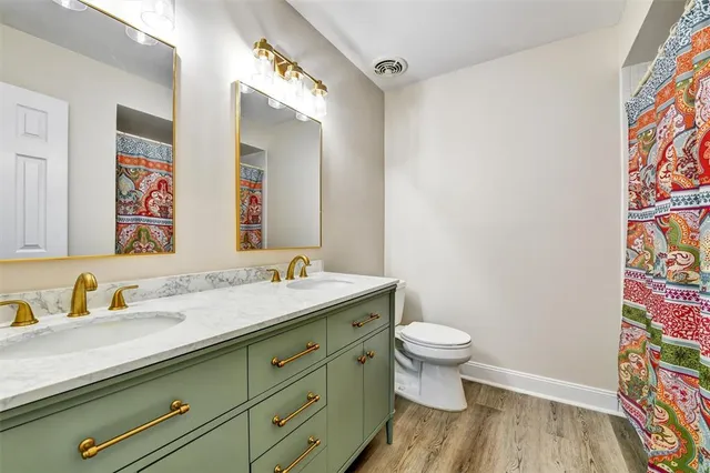 a bathroom with a granite countertop sink a mirror and a toilet