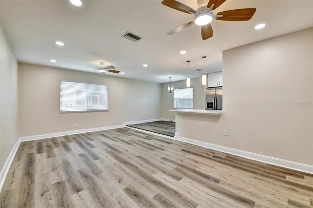 an empty room with wooden floor and windows