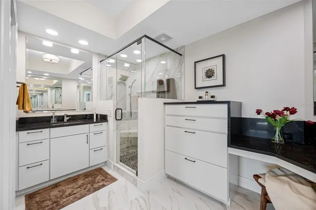 a spacious bathroom with a granite countertop sink mirror and cabinets