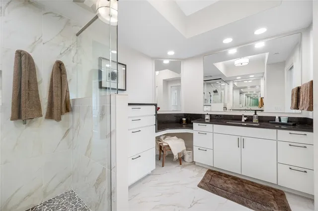 a large bathroom with a double vanity sink a mirror and a shower