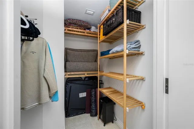 a view of walk in closet with clothes and shoes