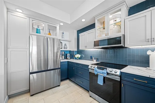 a kitchen with stainless steel appliances granite countertop a refrigerator a stove a sink and a microwave