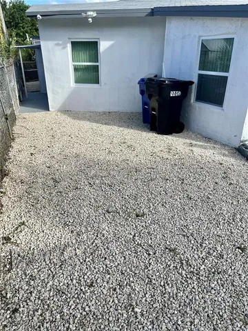 a backyard of a house with plants and outdoor seating