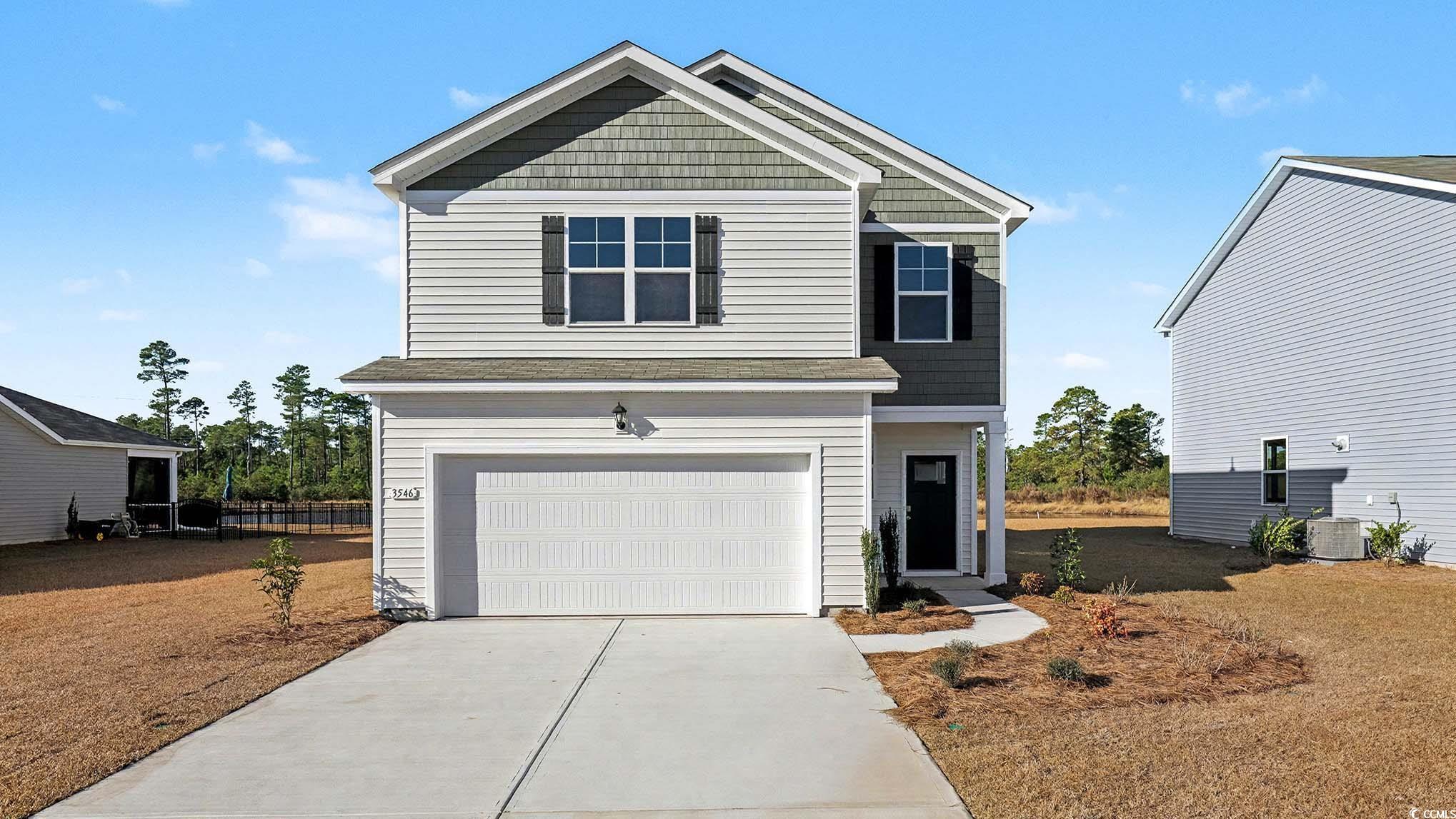 View of front facade with a garage and concrete driveway