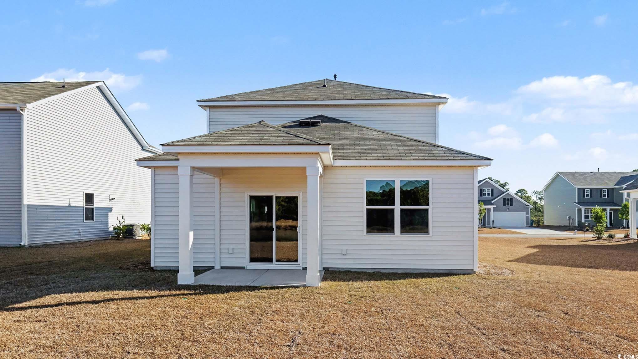 183 Pampa Drive Loris, SC 29569 - Photo 2 of 22 Back of house featuring a patio area, a shingled roof, and a lawn